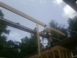 Carpenter setting a ridge beam over a new addition frame — Ice Dam Removal by Roofing Brothers in Hallieford